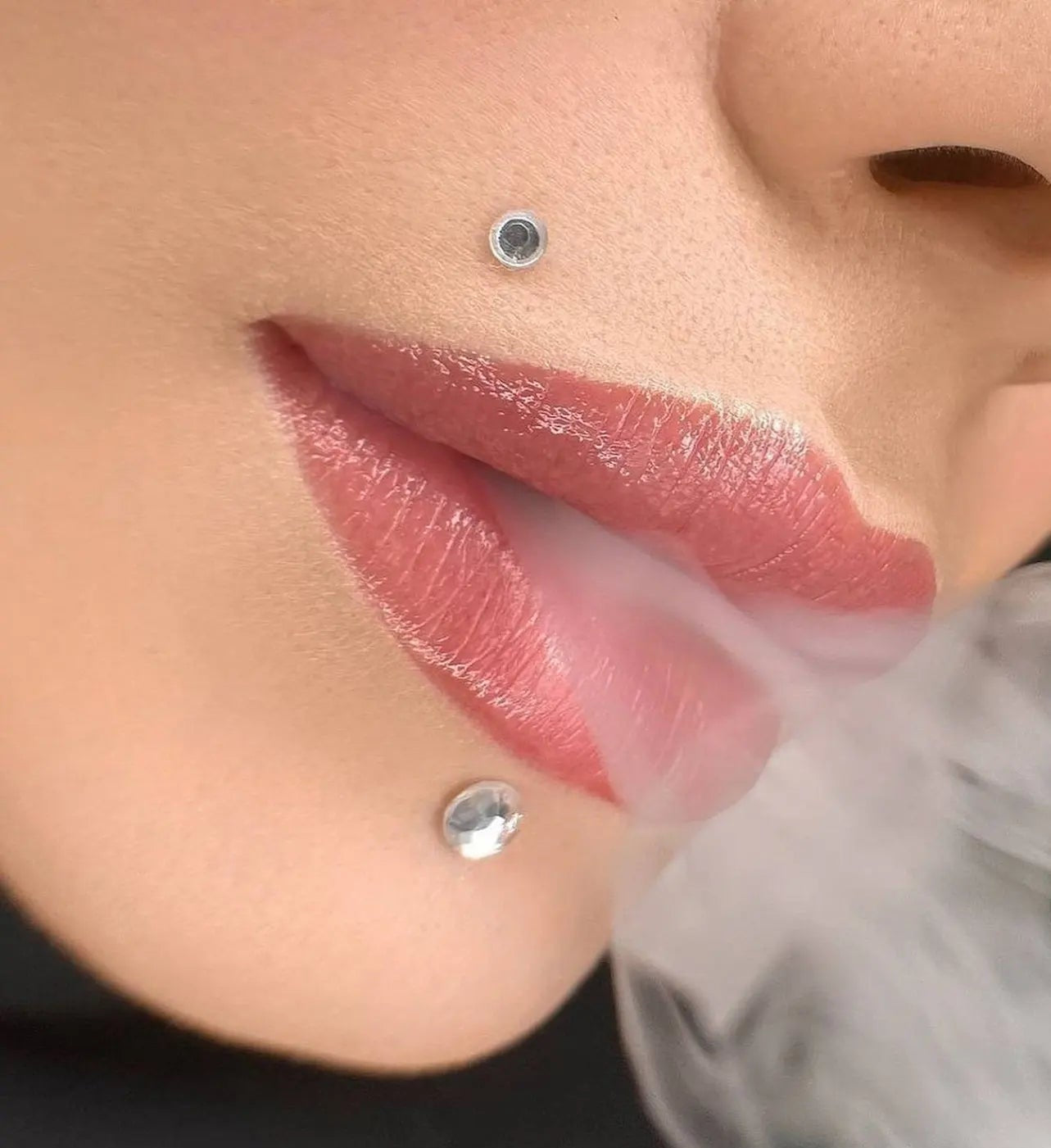 Close-up of a person's lips with a small stud earring, brand 'hanafy' visible.