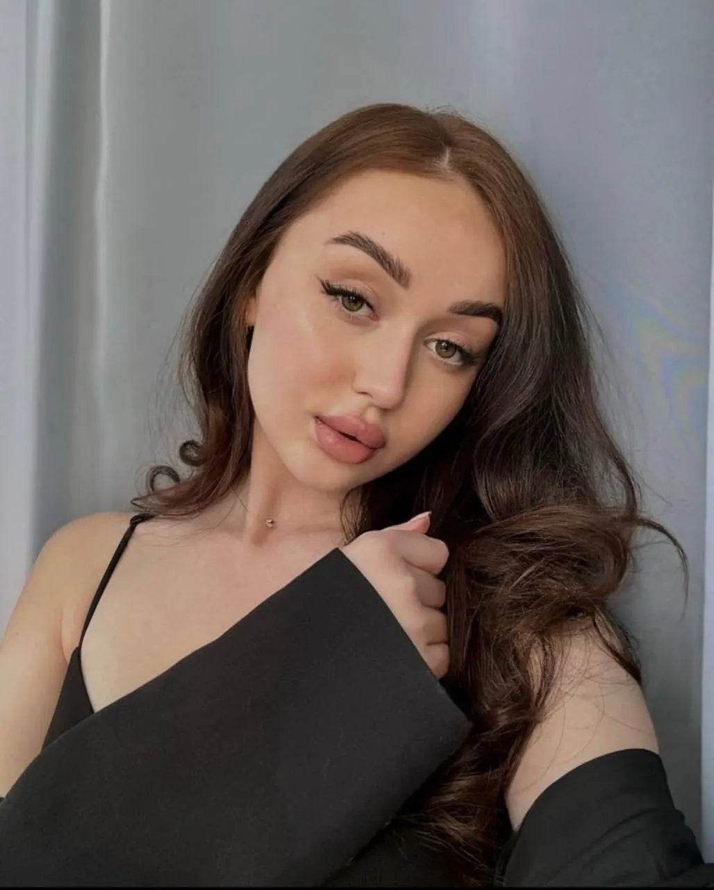 Woman wearing a black top against a gray background healed hanafy eyeliner from kostinetskaya eyes and brows